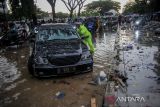 Petugas Kepolisian menghampiri mobil yang mogok akibat banjir di kawasan Gedebage, Bandung, Jawa Barat, Rabu (6/4/2022). Hujan dengan intensitas tinggi di berbagai titik di Kota Bandung membuat sejumlah wilayah tergenang air yang menyebabkan kemacetan di jalan nasional Soekarno-Hatta. ANTARA FOTO/Raisan Al Farisi/agr
