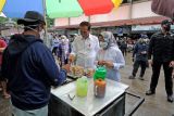 Presiden Joko Widodo (kedua kiri) didampingi Ibu Negara Iriana Joko Widodo (kedua kanan) berbincang dengan pedagang makanan saat kunjungan kerja ke Pasar Modern Angso Duo di Jambi, Kamis (7/4/2022). Dalam kunjungannya ke pasar terbesar di Jambi itu, Presiden Joko Widodo juga menyerahkan bantuan modal kerja dan Bantuan Langsung Tunai (BLT) minyak goreng untuk sejumlah pedagang dan keluarga penerima manfaat. ANTARA FOTO/Wahdi Septiawan/wsj.