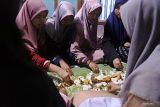 Sejumlah santri menyantap sajian berbuka puasa bersama dengan alas daun pisang di Pondok Pesantren Darun Najah, Desa Petahunan, Sumbersuko, Lumajang, Jawa Timur, Kamis (7/4/2022). Kegiatan membaca Al Quran dan berbuka puasa bersama diikuti ratusan santri putra dan putri tersebut merupakan agenda rutin selama bulan suci Ramadhan 1443 H. Antara Jatim/Seno/zk