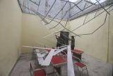 Pekerja merapihkan sisa puing atap yang ambruk di SDN Sawangan 1, Depok, Jawa Barat, Jumat (8/4/2022). Dua ruangan kelas di SDN Sawangan 1 tersebut mengalami kerusakaan pada bagian atap bangunan yang ambruk akibat hujan deras disertai angin kencang pada Kamis (7/4) sore hari. ANTARA FOTO/Asprilla Dwi Adha/foc.