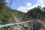 Sejumlah pekerja menyelesaikan pembangunan jembatan gantung Gladak Perak yang hancur terdampak awan panas guguran Gunung Semeru di Lumajang, Jawa Timur, Sabtu (9/4/2022). Kementerian Pekerjaan Umum dan Perumahan Rakyat membangun jembatan darurat untuk dipakai sementara oleh kendaraan roda dua. Antara Jatim/Seno/zk