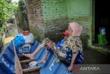 Relawan mengevakuasi seorang lansia saat banjir melanda Kampung Bojongasih, Dayeuhkolot, Kabupaten Bandung, Jawa Barat, Selasa (19/4/2022). Sebanyak 13 RW di Desa Dayeuhkolot dan ribuan jiwa terdampak banjir akibat luapan Sungai Citarum akibat hujan deras di Bandung Raya pada Senin (18/4/2022) malam. ANTARA FOTO/Raisan Al Farisi/agr