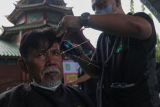 Warga mendapatkan layanan potong rambut gratis di Masjid Muhammad Cheng Hoo, Surabaya, Jawa Timur, Senin (18/4/2022). Kegiatan berbagi dalam bulan Ramadhan yang digelar Baksose Suroboyo dan Ngaji Komunitas Salon (Ngasal) Surabaya itu diikuti sekitar 450 orang. ANTARA FOTO/Didik Suhartono/aww.