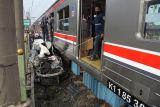 Sejumlah petugas berusaha mengevakuasi mobil Honda Mobilio yang tertabrak KRL Commuterline KA 1077 (Bogor-Jakarta Kota) di kawasan Rawageni, Ratu Jaya, Cipayung, Depok, Jabar, Rabu (20/4/2022). Kecelakaan yang terjadi di perlintasan sebidang itu menyebabkan terganggunya perjalanan KRL karena kereta harus melaju di satu jalur secara bergantian. ANTARA FOTO/Andika Wahyu/nym.