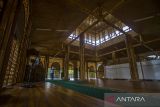 Seorang warga muslim menunaikan ibadah shalat di Masjid Bambu KH Abdul Qadir Hasan di kawasan desa wisata Kiram Park, Kabupaten Banjar, Kalimantan Selatan, Kamis (21/4/2022). Masjid yang hampir semua bangunan dari bahan bambu itu memiliki bentuk bangunan yang memadukan kearifan lokal dan unsur bangunan sejarah karena menyerupai jukung (perahu) dan bangunan pucuk masjid menyerupai masjid Sultan Surianyah yang merupakan masjid tertua di Kalsel. Foto Antaranews Kalsel/Bayu Pratama S.