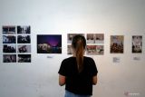 Pengunjung melihat karya foto yang dipamerkan pada pameran foto yang bertajuk Mesin Waktu di Galery Tibal Cafe Kota Blitar, Jawa Timur, Kamis (21/4/2022). Pameran foto karya sejumlah fotografer tersebut mengusung tema tentang perkembangan industri kopi dan olahannya sejak sebelum masa pandemi COVID-19, hingga saat ini. Antara Jatim/Irfan Anshori/Zk