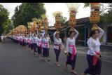 Umat Hindu menjunjung gebogan atau sesajen berisi buah, kue, bunga dan hiasan janur saat tradisi Mapeed di Pura Samuan Tiga, Desa Bedulu, Gianyar, Bali, Sabtu (23/4/2022). Tradisi tersebut kembali digelar setelah sempat ditiadakan selama dua tahun akibat pandemi COVID-19 dengan membagi setiap peserta sesuai jadwal yang telah ditentukan untuk mengurangi kerumunan. ANTARA FOTO/Nyoman Hendra Wibowo/nym.