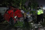  Polisi memeriksa mobil yang tertabrak kereta api di perlintasan  kereta api Jalan Manunggal Kebonsari, Surabaya, Jawa Timur, Senin (25/4/2022). Mobil Honda Brio bernomor polisi L 1120 QC yang melintas di perlintasan kereta di lokasi itu tertabrak KA Sancaka tambahan jurusan Surabaya-Yogyakarta yang mengakibatkan tiga orang penumpang mobil itu tewas di tempat. Antara Jatim/Erlangga/Ds/zk