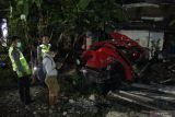  Polisi memeriksa mobil yang tertabrak kereta api di perlintasan  kereta api Jalan Manunggal Kebonsari, Surabaya, Jawa Timur, Senin (25/4/2022). Mobil Honda Brio bernomor polisi L 1120 QC yang melintas di perlintasan kereta di lokasi itu tertabrak KA Sancaka tambahan jurusan Surabaya-Yogyakarta yang mengakibatkan tiga orang penumpang mobil itu tewas di tempat. Antara Jatim/Erlangga/Ds/zk