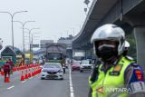 Anggota polisi memantau situasi kendaraan yang melaju di ruas jalan Tol saat uji coba ganjil genap di Tol Jakarta - Cikampek Karawang, Jawa Barat, Senin (25/4/2022). Uji coba ganjil genap tersebut untuk mengantisipasi peningkatan kendaraan yang akan berdampak perlambatan hingga kemacetan panjang pada arus mudik Lebaran 2022. ANTARA FOTO/M Ibnu Chazar/agr