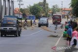 Sejumlah warga menunggu pengendara motor memberi sedekah dengan melempar uang di Jembatan Sewo, Jalur Pantura Sukra Indramayu, Jawa Barat, Senin (25/4/2022). Aksi mengambil uang sedekah menggunakan sapu tersebut dapat membahayakan keselamatan pengguna jalan terutama saat arus mudik. ANTARA FOTO/Dedhez Anggara/agr
