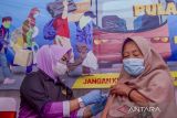 Vaksinator menyuntikkan vaksin COVID-19 kepada pemudik di Pos Pelayanan Ketupat Lodaya 2022, Rest Area KM 57, Karawang, Jawa Barat, Selasa (26/4/2022). Kapolri Jenderal Polisi Listyo Sigit Prabowo mengatakan pihaknya telah menyiapkan gerai vaksinasi COVID-19 dosis penguat untuk melayani pemudik guna mencegah lonjakan kasus COVID-19 setelah libur Idul Fitri 1443 H. ANTARA FOTO/M Ibnu Chazar/agr