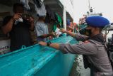 BAGI MASKER DI KAWASAN PELABUHAN. Personel Ditpolairud Polda Jawa Timur membagikan masker kepada anak buah kapal (ABK) di Pelabuhan Kalimas Surabaya, Jawa Timur, Rabu (27/4/2022). Pembagian masker kepada warga di kawasan pelabuhan itu bertujuan agar masyarakat tetap menggunakan masker dan menerapkan protokol kesehatan. Antara Jatim/Didik Suhartono/zk