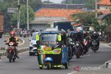 Pemudik yang menggunakan bajaj melintas jalur Pantura Simpang Lohbener, Indramayu, Jawa Barat, Jumat (29/4/2022). Pemudik menggunakan kendaraan khas ibukota untuk pulang kampung sehingga menjadi perhatian warga daerah karena keunikannya. ANTARA FOTO/Dedhez Anggara/agr