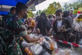 Anggota TNI melayani warga yang membeli paket sembako saat pasar murah Ramadhan 1443 H di Makorem 101/Antasari, Banjarmasin, Kalimantan Selatan, Jumat (29/4/2022). Korem 101/Antasari menggelar pasar murah Ramadhan yang menjual berbagai macam bahan kebutuhan pokok dengan harga lebih murah dibandingkan harga pasar dalam rangka menyongsong hari raya Idul Fitri 1443 H. Foto Antaranews Kalsel/Bayu Pratama S.