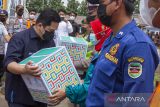 Menteri BUMN Erick Thohir (kiri) memberikan bingkisan kepada petugas gabungan mudik saat melakukan kunjungan kerja di Posko Pelayanan dan Monitoring Mudik, Purwakarta, Jawa Barat, Sabtu (30/4/2022). Kunjungan tersebut bertujuan untuk memberikan dukungan moral kepada semua petugas gabungan yang bekerja 24 jam memastikan arus mudik berjalan aman dan sehat. ANTARA FOTO/M Ibnu Chazar/agr
