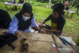 Perajin menyelesaikan pembuatan gelang simpai pesanan pengunjung di lokasi wisata Goa Limbuhang Haliau, Desa Haliau, Kabupaten Hulu Sungai Tengah, Kalimantan Selatan, Rabu (4/5/2022). Perajin mengaku pada libur Lebaran Idul Fitri 1 Syawal 1443 H saat ini permintaan kerajinan gelang simpai khas dayak meratus yang dijual seharga Rp30 ribu hingga Rp60 ribu tersebut meningkat di banding dua tahun sebelumnya. Foto Antaranews Kalsel/Bayu Pratama S.