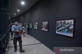 Wisatawan menyaksikan foto peristiwa bencana gempa dan tsunami saat mengunjungi objek wisata Museum Tsunami di Banda Aceh, Aceh, Sabtu (7/5/2022). Museum Tsunami Aceh  yang terdiri empat lantai dengan luas 2.500 meter itu, sejak awal liburan  Idul Fitri 1443 Hijriah ramai dikunjungi wisatawan lokal, wisatawan dari beberapa provinsi di Sumatera dan Pulau Jawa. ANTARA FOTO/Ampelsa