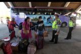 Anggota Polisi memeriksa penumpang yang turun dari bus antarkota antarprovinsi (AKAP) saat arus balik Lebaran di Terminal Mengwi, Badung, Bali, Minggu (8/5/2022). Pihak terminal mendata jumlah penumpang yang datang dari Pulau Jawa pada arus balik Idul Fitri 1443 H mencapai 3.051 orang. ANTARA FOTO/Nyoman Hendra Wibowo/nym.