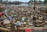 Kapal nelayan melintasi di lokasi tumpukan sampah botol plastik bekas bercampur sampah rumah tangga di kawasan Pelabuhan Perikanan Lampulo, Banda Aceh, Aceh, Minggu (8/5/2022). Keberadaan sampah botol plastik bekas di pelabuhan perikanan yang bermuara ke perairan pantai itu diduga dibuang pengunjung dan warga tempat selama liburan Idul Fitri 1443 Hijriah  akibat kurangnya kesadaran menjaga lingkungan dan ancaman kerusakan ekosistem laut. ANTARA FOTO/Ampelsa