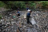 Pemerhati lingkungan membersihkan sampah pada aliran sungai dalam aksi 'River Clean Up' di Sungai Desa Jimbaran, Kuta Selatan, Badung, Bali, Sabtu (14/5/2022). Kegiatan yang diikuti berbagai komunitas dan relawan lingkungan tersebut digelar untuk mengurangi jumlah sampah pada aliran sungai dan melindungi sungai di Bali serta mengantisipasi risiko bencana. ANTARA FOTO/Nyoman Hendra Wibowo/nym.