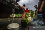 Warga antre untuk mendapatkan air bersih di Kelurahan Pelambuan, Banjarmasin, Kalimantan Selatan, Selasa (17/5/2022). Warga di Kelurahan Pelambuan tepatnya di jalan PM Noor Banjarmasin mengeluhkan sejak dua bulan terakhir distribusi air bersih dari Perusahaan Daerah Air Minum (PDAM) Bandarmasih mengalami penurunan bahkan hingga mati total akibatnya warga terpaksa menggunakan air aliran sungai serta membeli air bersih untuk memenuhi kebutuhan sehari-hari. Foto Antaranews Kalsel/Bayu Pratama S.