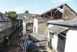 Warga melihat rumah yang tertimpa pohon akibat angin kencang di Bedahan, Depok, Jawa Barat, Senin (16/5/2022). Hujan deras disertai angin kencang yang terjadi pada Minggu (15/5) tersebut mengakibatkan pohon tumbang, sejumlah atap rumah dan restoran mengalami kerusakan. ANTARA FOTO/Asprilla Dwi Adha/rwa.