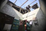 Warga merapikan barang-barang yang tertimpa atap rumah akibat angin kencang di Bedahan, Depok, Jawa Barat, Senin (16/5/2022). Hujan deras disertai angin kencang yang terjadi pada Minggu (15/5) tersebut mengakibatkan pohon tumbang, sejumlah atap rumah dan restoran mengalami kerusakan. ANTARA FOTO/Asprilla Dwi Adha/rwa.