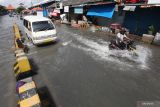 Sejumlah kendaraan bermotor menerjang banjir rob di Jalan Kalimas Baru, Surabaya, Jawa Timur, Rabu (18/5/2022).  Pasang air laut yang tinggi menyebabkan akses jalan menuju Pelabuhan Kalimas dan penyeberangan Ujung (Surabaya)-Kamal (Madura) tersebut terendam banjir rob. Antara Jatim/Didik Suhartono
