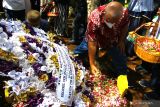 Seorang pelayat menaburkan bunga di atas makam almarhum Achmad Yurianto di komplek pemakaman umum Dadaprejo, Batu, Jawa Timur, Minggu (22/5/2022). Mantan juru bicara Satgas Penanganan COVID-19 tersebut meninggal di usia 60 tahun pada Sabtu (21/5) pukul 18.58 WIB setelah berjuang melawan penyakit kanker usus.  Antara Jatim/Ari Bowo Sucipto/Ds