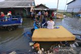 Warga melihat kondisi rumahnya yang terendam banjir rob atau air laut pasang di Desa Karangsong, Indramayu, Jawa Barat, Senin (23/5/2022). Banjir rob tersebut mengakibatkan puluhan rumah warga di pesisir pantai terendam setinggi 60-90 centimeter dan membuat aktivitas warga terhambat. ANTARA FOTO/Dedhez Anggara/agr