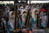 Wisatawan mengikuti pertunjukan angklung di Saung Angklung Udjo, Bandung, Jawa Barat, Senin (23/5/2022). Saung Angklung Udjo yang menjadi destinasi wisata prioritas di Kota Bandung kembali membuka kunjungan bagi wisatawan dengan kapasitas 100 persen seiring dengan pelonggaran dari pemerintah. ANTARA FOTO/Raisan Al Farisi/agr
