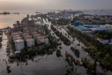 Foto udara kondisi banjir limpasan air laut ke daratan atau rob yang merendam kawasan Pelabuhan Tanjung Emas Semarang, Jawa Tengah, Senin (23/5/2022). Banjir rob dengan ketinggian bervariasi hingga mencapai 1,5 meter itu disebabkan oleh tingginya pasang air laut serta adanya tanggul yang jebol di kawasan tersebut, sementara itu personel dari Basarnas, TNI-Polri dan relawan diterjunkan untuk membantu evakuasi para pekerja maupun warga. ANTARA FOTO/Aji Styawan/rwa.