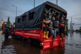 Sejumlah pekerja pelabuhan menumpang truk evakuasi Basarnas untuk menembus banjir limpasan air laut ke daratan atau rob yang merendam kawasan Pelabuhan Tanjung Emas Semarang, Jawa Tengah, Senin (23/5/2022). Banjir rob dengan ketinggian bervariasi hingga mencapai 1,5 meter itu disebabkan oleh tingginya pasang air laut serta adanya tanggul yang jebol di kawasan tersebut, sementara itu personel dari Basarnas, TNI-Polri dan relawan diterjunkan untuk membantu evakuasi para pekerja maupun warga. ANTARA FOTO/Aji Styawan/rwa.