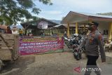 Aparat keamanan berjaga di lokasi saat penutupan Pasar Hewan Sibreh, di Desa Sibreh, Kecamatan Sibreh, Kabupaten Aceh Besar, Aceh, Rabu (25/5/2022). Ratusan pedagang terpaksa membawa pulang kembali ternaknya karena pemerintah Kabupaten Aceh Besar menutup  pasar hewan di daerah itu guna mencegah peningkatan kasus Penyakit Muluk dan Kuku (PMK) pada ternak sapi yang saat ini  bertambahn mencapai 438 ekor, 69 ekor sembuh dan tujuh ekor mati. ANTARA FOTO/Ampelsa