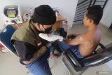 Relawan yang tergabung dalam Better Youth Foundation menghapus tato peserta saat layanan hapus tatto gratis di aula Masjid Qoobah, Kediri, Jawa Timur, Sabtu (28/5/2022). Kegiatan hapus tato tanpa dipungut biaya yang hanya mensyaratkan peserta hafal minimal lima ayat surat Ar-Rahman tersebut diikuti oleh sedikitnya 28 orang dari sejumlah daerah. Antara Jatim/Prasetia Fauzani/zk