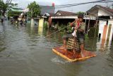 Warga menggunakan perahu rakitan saat menerobos banjir di Kelurahan Paccinongan, Kecamatan Somba Opu, Kabupaten Gowa, Sulawesi Selatan, Jumat (27/5/2022). Ratusan rumah di daerah itu terendam banjir usai diguyur hujan deras sejak Kamis (26/5/2022) sore. ANTARA FOTO/Arnas Padda/rwa.
