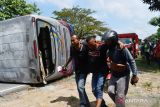 Warga menolong salah seorang penumpang korban kecelakaan Bus Sugeng Rahayu di Balerejo, Kabupaten Madiun, Jawa Timur, Selasa (31/5/2022).  Penyebab kecelakaan yang mengakibatkan 20 penumpang mengalami luka itu masih dalam penyelidikan pihak kepolisian. Antara Jatim/Siswowidodo/zk