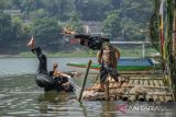 Pesilat memeragakan gerakan pencak silat saat upacara tradisi ngalokat cai di Situ Ciburuy, Padalarang, Kabupaten Bandung Barat, Jawa Barat, Rabu (1/6/2022). Tradisi ngalokat cai yang digelar bertepatan dengan Hari Lahir Pancasila tersebut sebagai bentuk rasa syukur atas keberadaan air yang melimpah serta mengkampanyekan kepada masyarakat untuk menjaga kelestarian air. ANTARA FOTO/Raisan Al Farisi/agr