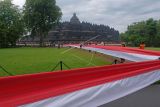 Peserta membentangkan bendera merah putih mengelilingi Candi Borobudur saat peringatan Hari Lahir Pancasila di Taman Wisata Candi (TWC) Borobudur, Magelang, Jawa Tengah, Rabu (1/6/2022). Kegiatan pembentangan bendera sepanjang satu kilometer yang diikuti oleh berbagai elemen masyarakat tersebut sebagai wujud semangat persatuan dan kesatuan bangsa dalam menjaga dasar negara Pancasila. ANTARA FOTO/Anis Efizudin/nym.