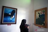 Pengunjung melihat lukisan yang dipamerkan saat pameran lukisan bertajuk Tanda Cinta Untuk Bung di De Kolonial Cafe Blitar, Jawa Timur, Kamis (2/6/2022). Pameran lukisan karya 4 pelukis wanita asal Jawa Timur tersebut digelar selama satu bulan penuh, dalam rangka peringatan hari kelahiran dan kematian (Haul) Presiden Soekarno (Bulan Bung karno) yang jatuh pada bulan Juni. ANTARA Jatim/Irfan Anshori/zk