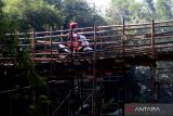  Warga melintas di atas jembatan mambu di Desa Ngadi, Kediri, Jawa Timur, Jumat (3/6/2022). Pembongkaran jembatan darurat di desa Ngadi penghubungkan Kediri dengan Tulungagung mengakibatkan warga terpaksa memutar melalui jembatan Wijaya Kusuma atau untuk pengguna sepeda motor dan pejalan kaki dapat melalui jembatan bambu. Antara Jatim/Prasetia Fauzani/zk