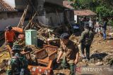 Anggota TNI membantu evakuasi barang warga seusai banjir bandang di Kampung Kaum Kidul, Ciwidey, Kabupaten Bandung, Jawa Barat, Selasa (7/6/2022). Banjir bandang yang terjadi pada Senin (6/6/2022) menyebabkan belasan rumah rusak ringan dan berat serta satu jembatan penguhubung antar desa terputus. ANTARA FOTO/Raisan Al Farisi/agr