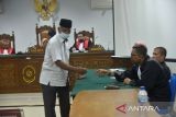 Terdakwa Kepala Bidang Pembibitan dan Produksi Dinas Peternakan Aceh, Alimin Hasan bersalaman dengan pengacaranya seusai sidang dengan agenda pembacaan putusan majelis hakim di Pengadilan Tipikor Banda Aceh, Aceh, Selasa (7/6/2022). Dua terdakawa dari pejabat Dinas Peternakan Aceh, Alimin Hasan dan Ichwan Perdana serta dua rekanan pemenang tender CV Menara Company divonis bebas oleh majelis hakim setelah tidak terbukti melakukan tindak pidana korupsi dalam kasus pengadaan sebanyak 225 ekor sapi Bali tahun 2017 dengan anggaran sebesar Rp3,4 miliar. ANTARA FOTO/Ampelsa.