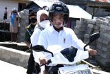 Jokowi dan Iriana berboncengan mengendarai sepeda motor listrik