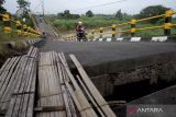 Pengendara melintas di Jembatan Kacangan yang rusak di Desa Bulurejo, Gresik, Jawa Timur, Kamis (9/6/2022). Jembatan sepanjang 90 meter yang menghubungkan antara Desa Bulurejo dengan Desa Gluranploso itu rusak sejak Desember 2021 dan masih menjadi pilihan utama warga setempat untuk menyebrang meskipun membahayakan keselamatan. ANTARA Jatim/Rizal Hanafi/Zk