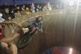 Pengendara sepeda motor perempuan Gita Selfira melakukan atraksi tong setan di Pasar Malam Alun-alun Kidul, Solo, Jawa Tengah, Selasa (7/6/2022). Atraksi permainan tong setan yang dilakukan perempuan tersebut menjadi daya tarik tersendiri hiburan rakyat pasar malam. ANTARA FOTO/Mohammad Ayudha/foc.