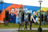 Warga berjalan di depan mural bergambar Gubernur Jawa Barat Ridwan Kamil dan Wali Kota Bogor Bima Arya di Alun-Alun Kota Bogor, Jawa Barat, Senin (6/6/2022). Mural dengan tema Bogor Berlari, Jabar Juara, dan Indonesia Juara tersebut dibuat seniman mural dalam rangka memeriahkan Hari Jadi Bogor ke-540 dan menjadi lokasi favorit warga untuk berfoto. ANTARA FOTO/Arif Firmansyah/wsj.