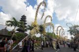 Sejumlah pemuda memasang penjor atau bambu yang dihiasi janur dan hasil bumi untuk dilombakan dalam festival penjor dengan tema 'ngerobok' di Desa Adat Kerobokan, Badung, Bali, Sabtu (11/6/2022). Kegiatan yang digelar dalam nuansa Hari Raya Galungan dan Kuningan tersebut diikuti 52 banjar atau dukuh untuk merayakan kemenangan 'Dharma' (kebenaran) melawan 'Adharma' (kejahatan) serta pelestarian budaya Bali bagi generasi muda. ANTARA FOTO/Nyoman Hendra Wibowo/nym.