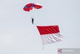 Prajurit TNI AL membawa bendera merah putih saat terjun payung dalam acara 'Naval Airbase Open Day' di Apron Hanggar Lanudal Juanda, Surabaya, Jawa Timur, Minggu (12/6/2022). Atraksi tersebut untuk memeriahkan HUT ke-66 Penerbangan TNI AL. ANTARA Jatim/Umarul Faruq/zk